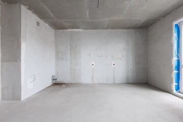 Obraz premium interior of the apartment without decoration in gray colors. rough finish