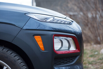 headlight of modern prestigious car closeup. beautiful headlights of a car. dark gray color, red edging. part of the front, the car is unrecognizable. direction indicators on a sports car. side view