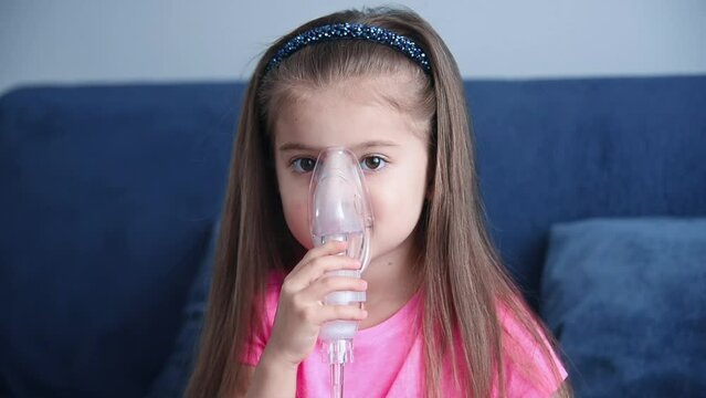 Portrait of little girl in an inhalation mask. Children's lung health concept. Slow Motion Effect.