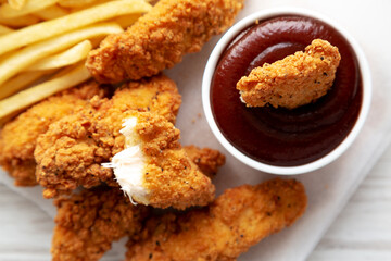 Homemade Chicken Tenders with French Fries and BBQ Sauce, top view. Flat lay, overhead, from above. Close-up.