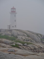 The beautiful Peggys Cove Lighthouse on the coast of Nova Scotia in thick fog