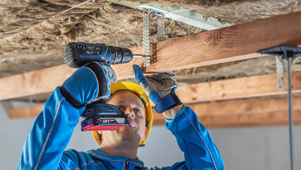 Lowering and insulate the ceiling. Fixing a wooden prism using suspend tin sheet to the...