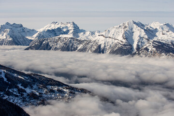 Swiss alps during winter with valley covered by clouds