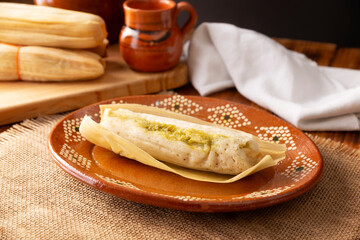 Tamales. hispanic dish typical of Mexico and some Latin American countries. Corn dough wrapped in corn leaves. The tamales are steamed.