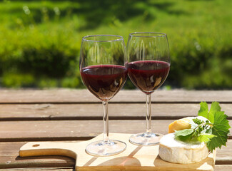 Various sorts of cheese and two glasses of the natural homemade red wine