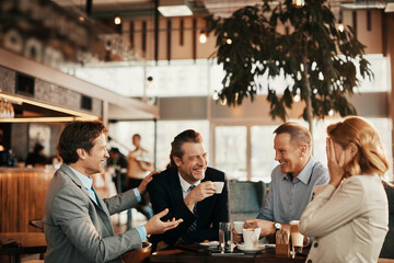 Happy diverse business people laughing in cafe