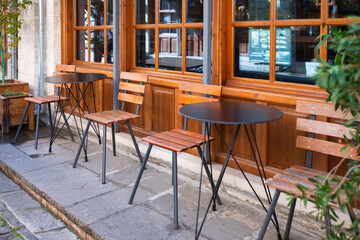 Street view of a coffee terrace with tables and chairs. Free cafe table. Outdoor empty coffee and restaurant terrace