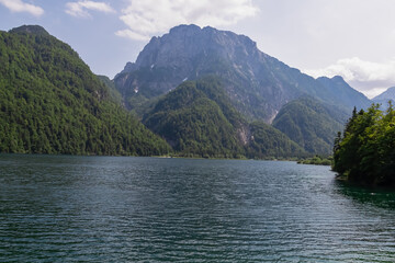 Scenery of Lake Predil with panoramic view of majestic mountain peak Cima del Lago, Tarvisio, Friuli Venezia Giulia, Italy. Tranquil scene in summer. Alpine landscape in Julian Alps, border Slovenia