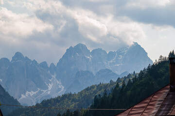 Small village Plezzut with panoramic view of majestic mountain range Julian Alps, Tarvisio, Friuli Venezia Giulia, Italy. High alpine road on Predil Pass. Looking at Jof Fuart and Cima del Vallone