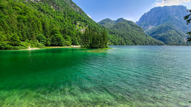 Scenery of Lake Predil with panoramic view of majestic mountain peak Cinque Punte, Tarvisio, Friuli Venezia Giulia, Italy. Tranquil scene in summer. Alpine landscape in Julian Alps, border Slovenia