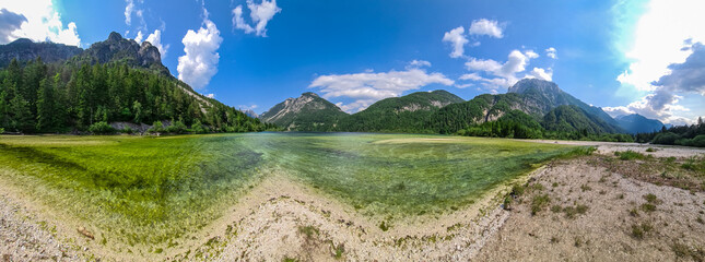 Fototapeta premium Scenery of Lake Predil with panoramic view of majestic mountain peak Cinque Punte, Tarvisio, Friuli Venezia Giulia, Italy. Tranquil scene in summer. Alpine landscape in Julian Alps, border Slovenia