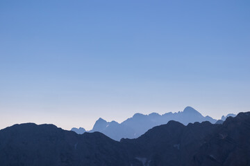 Silhouette of mountain peaks of wild Julian Alps seen on scenic hiking trail to majestic summit...