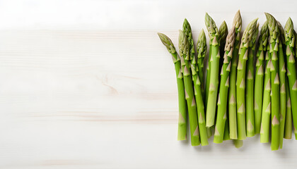 Heap of fresh asparagus on white wooden table top view