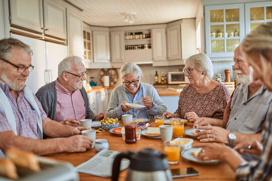 Happy senior people eating breakfast at home