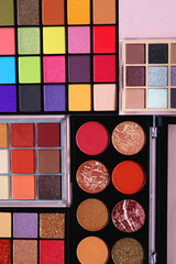 Various colorful eyeshadow palettes on bright pink background. Flat lay.