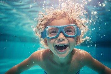 a child, a boy, swims in the pool wearing goggles for swimming underwater.