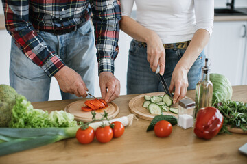 Cropped view of hands of caucasian old married man and wife prepare healthy salad, cutting thin...