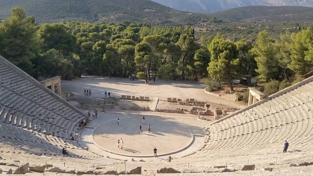 panning inside ancient theater in epidavros, greece (old ruin archaeological site in the mountains) huge arena travel destination (summer tourism in europe)