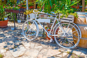 Fototapeta na wymiar Nessebar (Nesebyr) Bulgaria - Restaurant on a beautiful sunny day with a white bicycle attached to the fence.