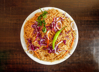 Plain pulao with coriander, onion and cabbage served in plate isolated wooden background top view indian spices and pakistani food