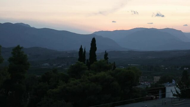pan across landscape with mountains and small european village in agrolis greece (night time, dusk, blue hour, sunset footage) mykines