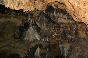 Close-up of clay stalactites in an underground cave. Speleological research and study of caves