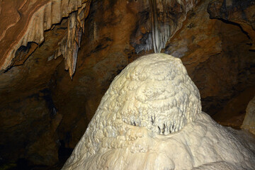 Close-up of clay stalagmites rising from the floor of an underground cave. Speleological research...