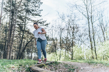 Naklejka na ściany i meble A determined, beautiful, overweight woman passionately engages in her outdoor workout routine at the park, embracing her journey to a healthier and happier self. 