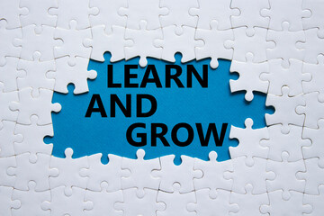 Learn and grow symbol. Concept words Learn and grow on white puzzle. Beautiful blue background. Business and Learn and grow concept. Copy space.