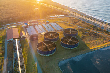 Aerial view of sewage water treatment plant by the sea at sunset. Industrial waste water treatment...