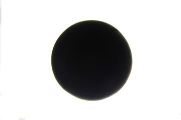 Pelota de goma negra para juegos de frontón, con forma esférico en el centro presentando un original diseño abstracto de contraste con fondo blanco - obrazy, fototapety, plakaty