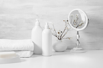Soft light bathroom decor in white color, cosmetics product,mirror, towel, soap, dried flowers,...