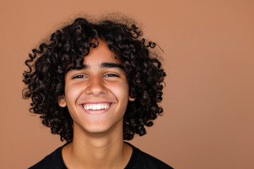 Happy Adolescent Boy with Bouncy Curls on Tan Background