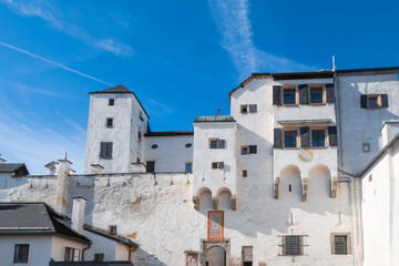 View of Hohensalzburg Fortress against blue sky, a large medieval fortress on a hilltop looking over Salzburg city.