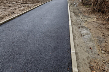 installation of concrete curb into concrete. in the space of the road, which so far has only a...