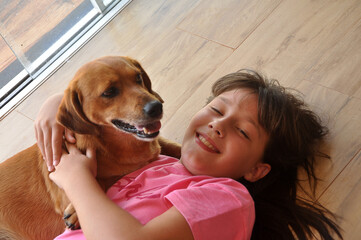 menina criança feliz com cachorro caramelo doméstigo, amor canino, cão amigo e companheiro 