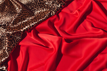 Luxurious fabrics draped, rich red and wild cat print, creative background, trendy pattern combo. 