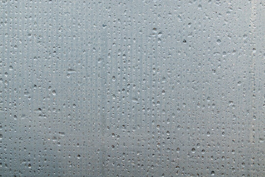 A foggy sheet of transparent plastic with a mesh structure. Water drops are arranged in lines. Close-up. Background. Texture. - Powered by Adobe