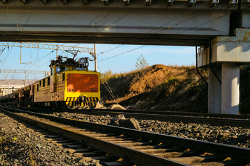 Industrial electric locomotive alternating current pulls opened freight dump rail cars