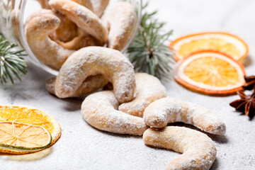 Christmas horseshoe cookies, bagels with powdered sugar. Christmas tree branches for decoration. Light background