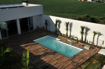 area externa de edicula com piscina e paisagismo com chão de porcelanato amadeirado deck 