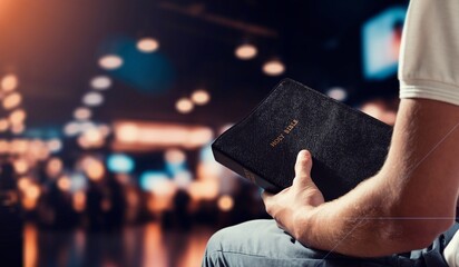 Man praying hold holy bible book