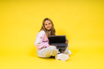 Teenager girl with notebok computer laptop sitting in studio