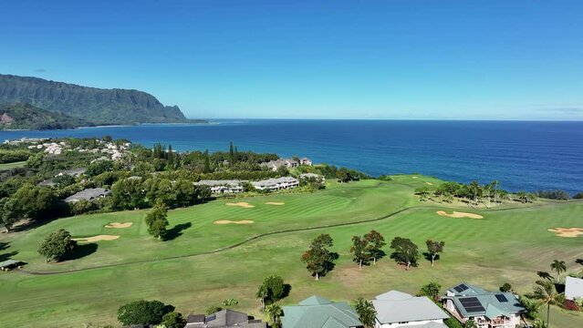 Aerial Kauai Hawaii luxury golf club homes Hanalei bay. Expensive luxury homes, resort, condominium and golf club near coast. Recreation and tourism. Economy tourism. Warm tropical climate.