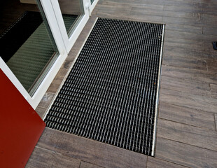  industrial mat cleaning zones at the entrance to the building. A black plastic-metal mat in the...