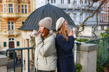 two girls are standing in the beautiful colonnade with mineral water in Karlovy Vary 