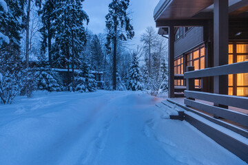 Beautiful wooden house with light in the windows. Twilight. A magnificent winter landscape with...