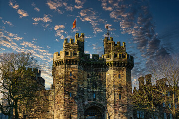 Historic stone castle with towers against a blue sky with scattered clouds at sunset in Lancaster.