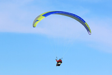 Paraglider flying in a blue sky