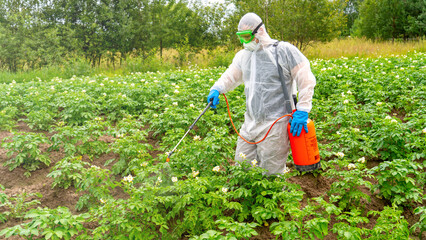 Worker in protective suit treating plants with pesticides, modern agriculture and chemical fertilizers © Антон Скрипачев